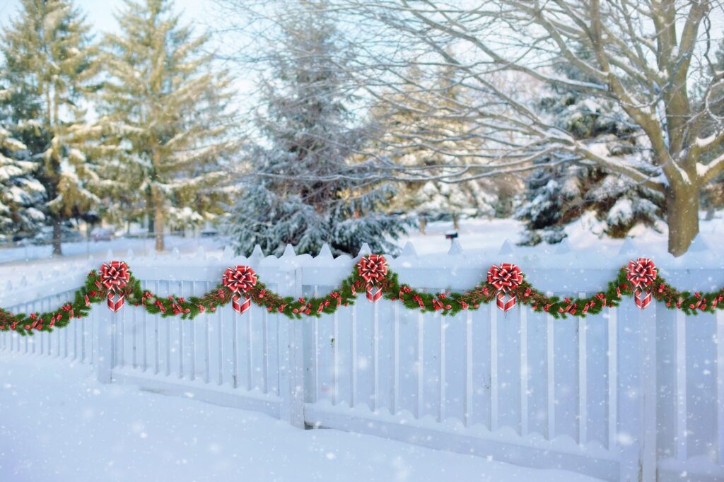 Outdoor green red gardland on white fence -Christmas Décor Inspiration