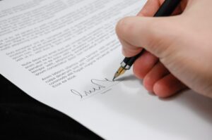 man's hand signing legal document - ¬¬¬¬11 Must-Have Legal Landlord Documents